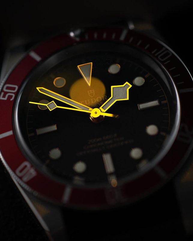Tudor Black Bay with luminous hands and markers glowing in low light, demonstrating the lume quality that distinguishes genuine watches