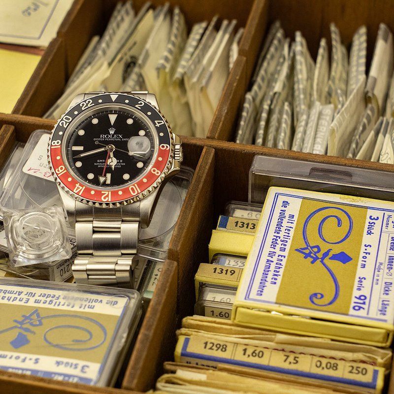 Expert watchmaker examining a luxury timepiece in our workshop